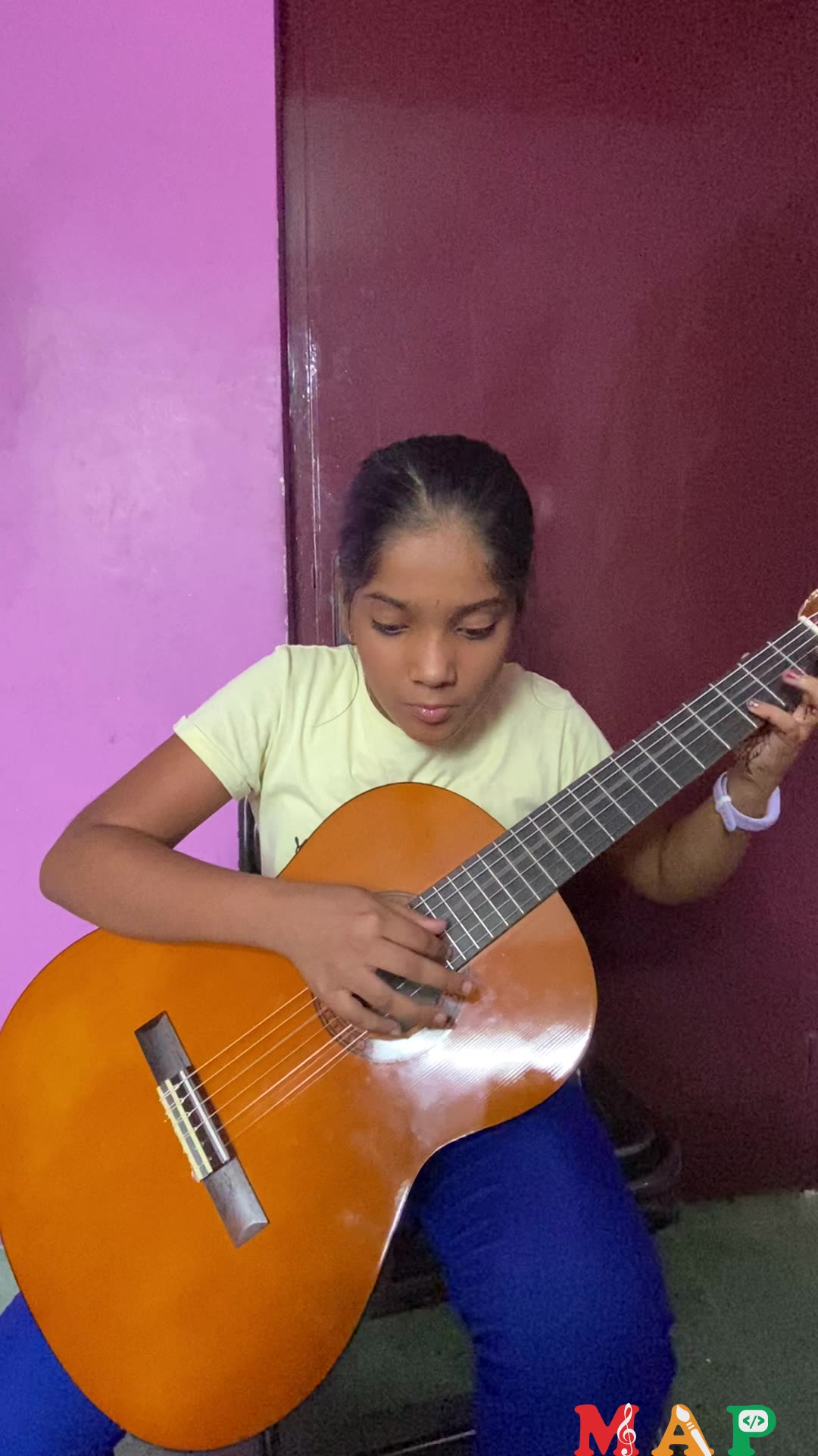Student plays guitar for an online lesson